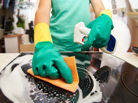 Kitchen surfaces being cleaned during move in cleaning service